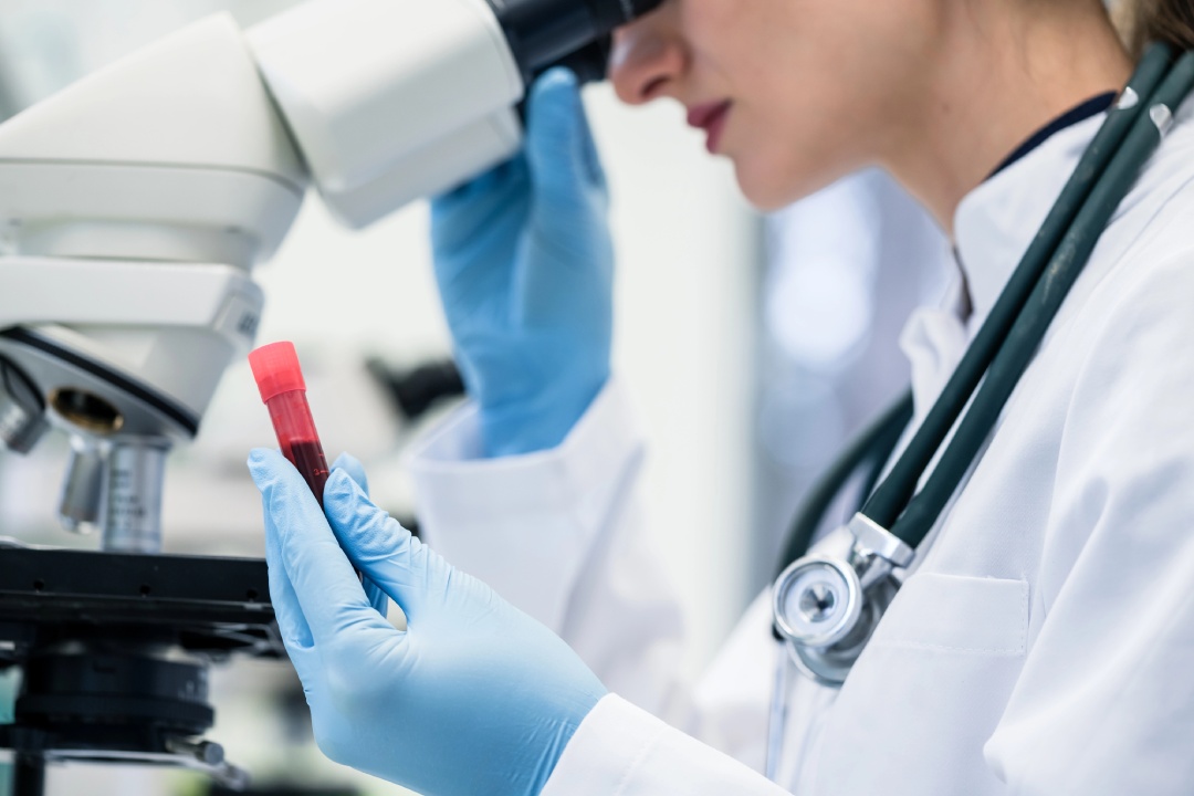 Lab technician analyzing blood sample—accurate diagnostics and screenings available at your local STD Clinic.