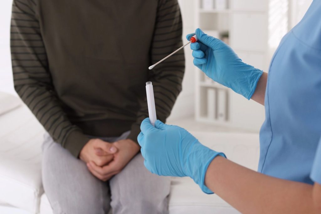 Healthcare professional readying swab and test tube in medical setting — same day std test houston, fast, discreet screening