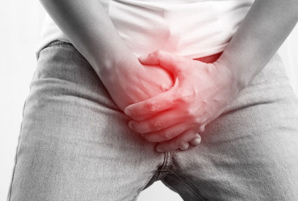Person clutching groin with red pain highlight, visualizing symptoms and need for prompt sti testing houston services