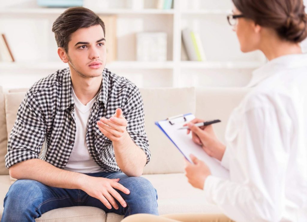 A counselor discusses gay men gonorrhea testing Houston options with a young patient during a health consultation. 