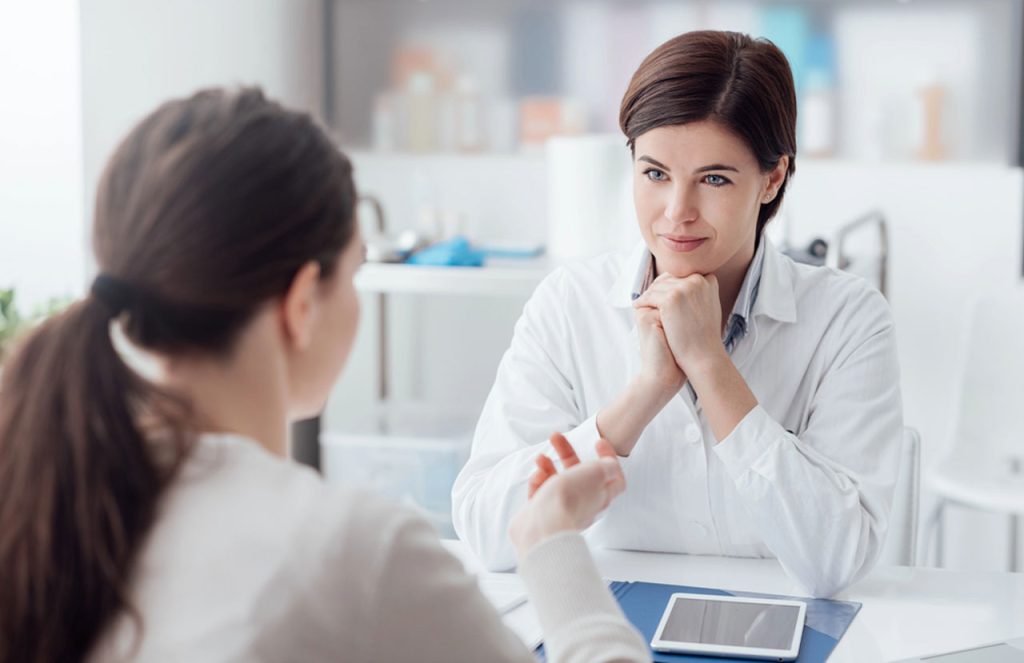 Supportive doctor listening to a patient in a professional Houston clinic offering private same day std tests.
