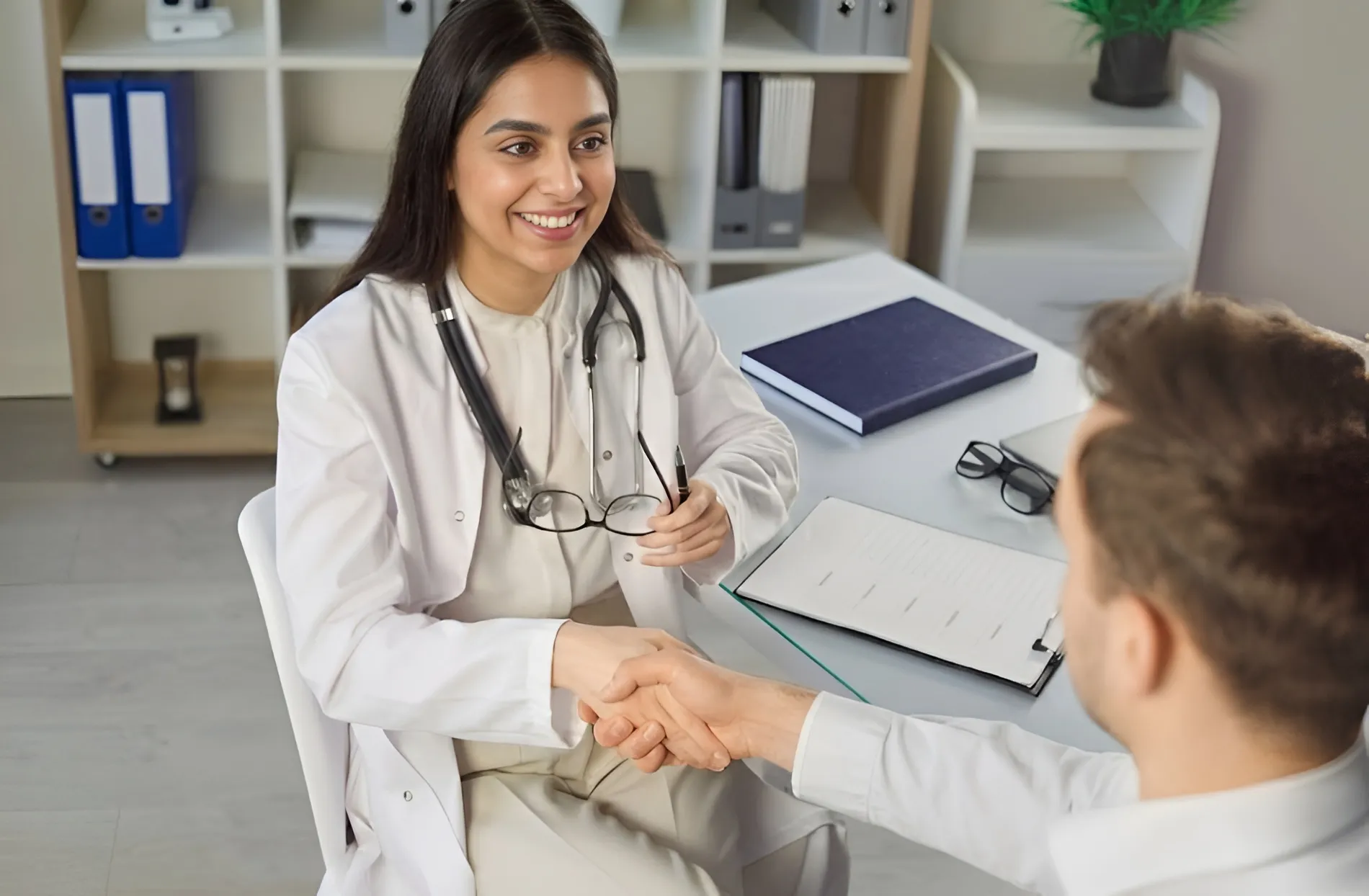 Dr. Anita Leal smiling and shaking hands with a patient during a routine sexual health checkup appointment.